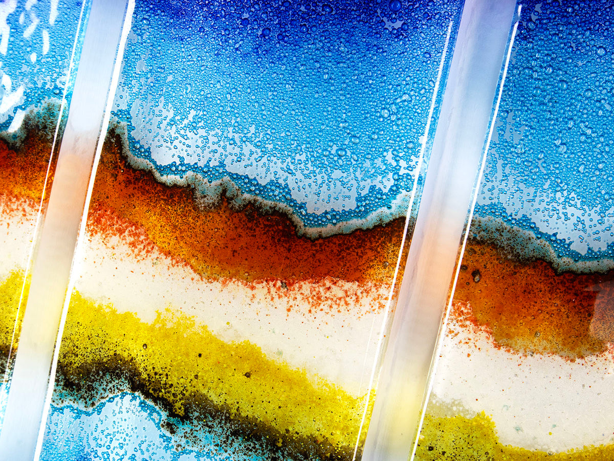 Three fused glass panels, forming a handmade triptych wall art piece, designed in coastal bright colours.