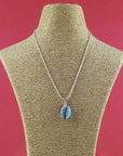 Artisan fused glass pendant necklace, handcrafted in our studio, with delicate blues and a flash of bright red. Finished with a sterling silver chain and fittings, hung on a mannequin. 