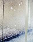Details on a fused glass staggered triptych featuring a hand-painted sailboat design in a soft and misty colour-way. 