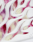 Close up of a signature on an art frame with hand-cut fused glass shoal of fish in a sunset pink colour-way, inspired by the ocean. 