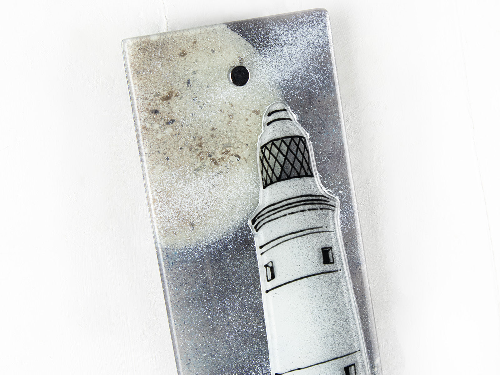 Close up of fused glass extra small wall panel, featuring a lighthouse design with a full moon. A soft coastal piece of wall art. 