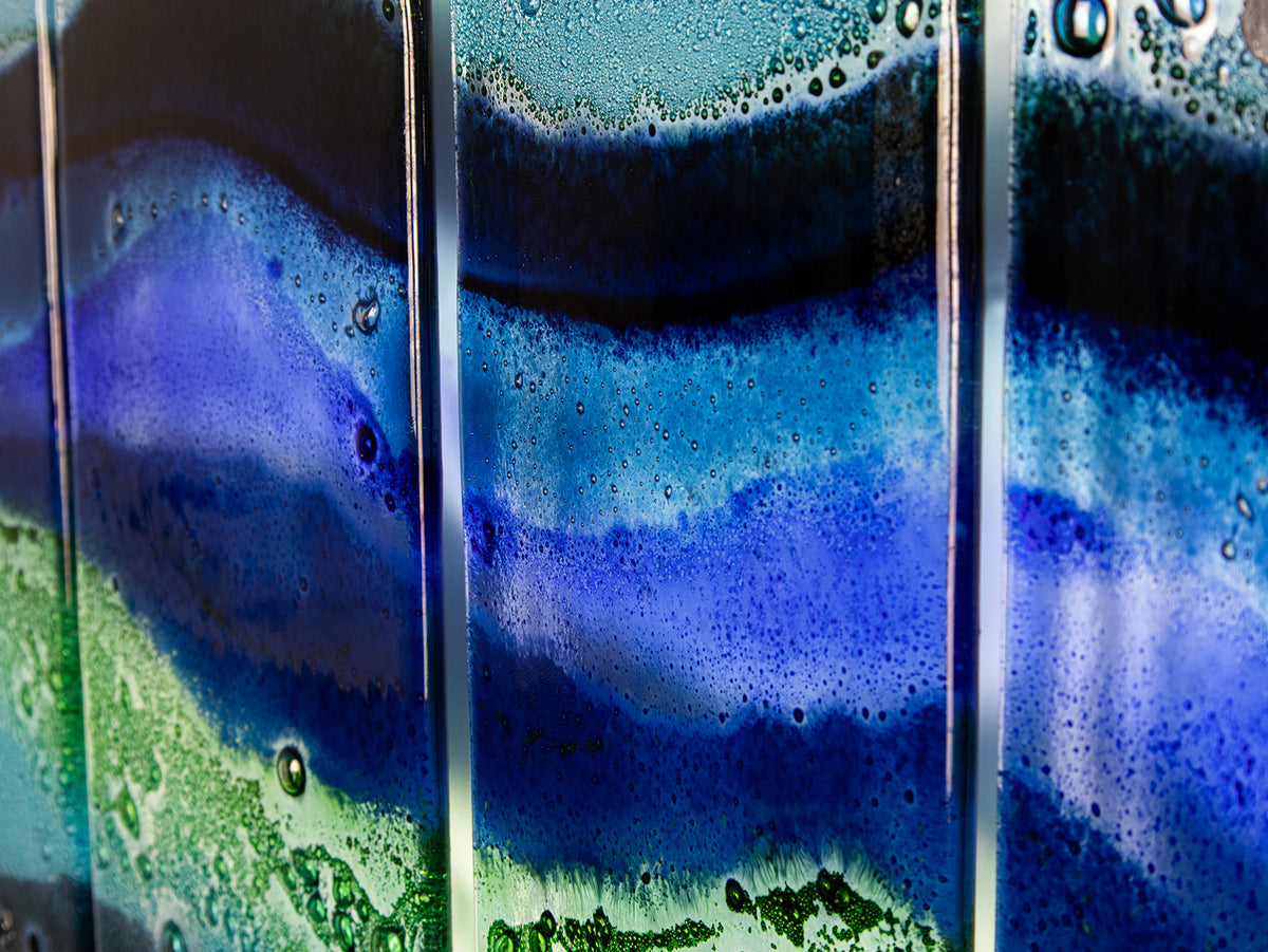 A detailed image of a fused glass quintych featuring an ocean blue colour-way, inspired by the coast 