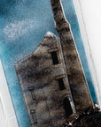 Close up of a fused glass tin mine wall panel set against a moody dark sky, creating a soft Cornish inspired piece of wall art. 