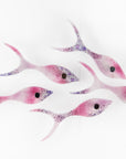 Small fused glass wall display of individual handmade fish in rose pinks and bubbled purple hues. 
