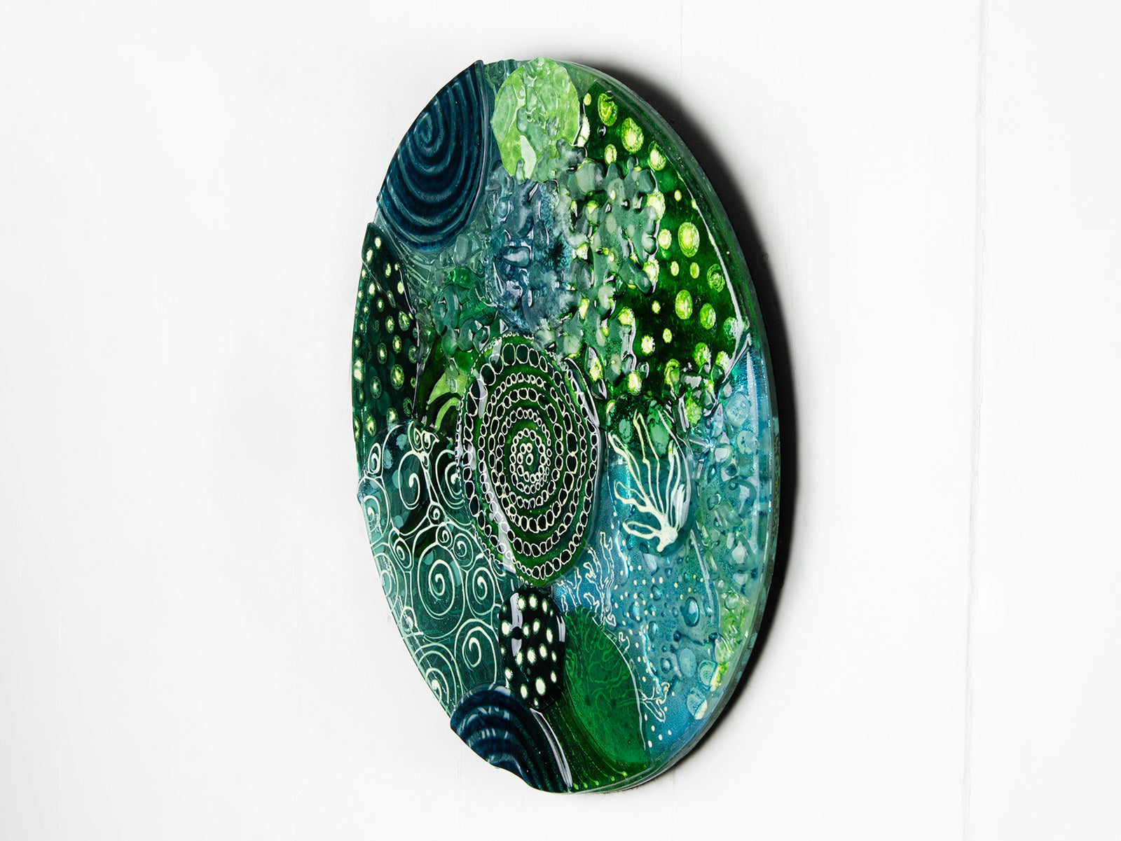 Fused glass round panel, handmade using ocean colours and botanical and organic painted designs. An abstract, coastal inspired piece of wall art. 