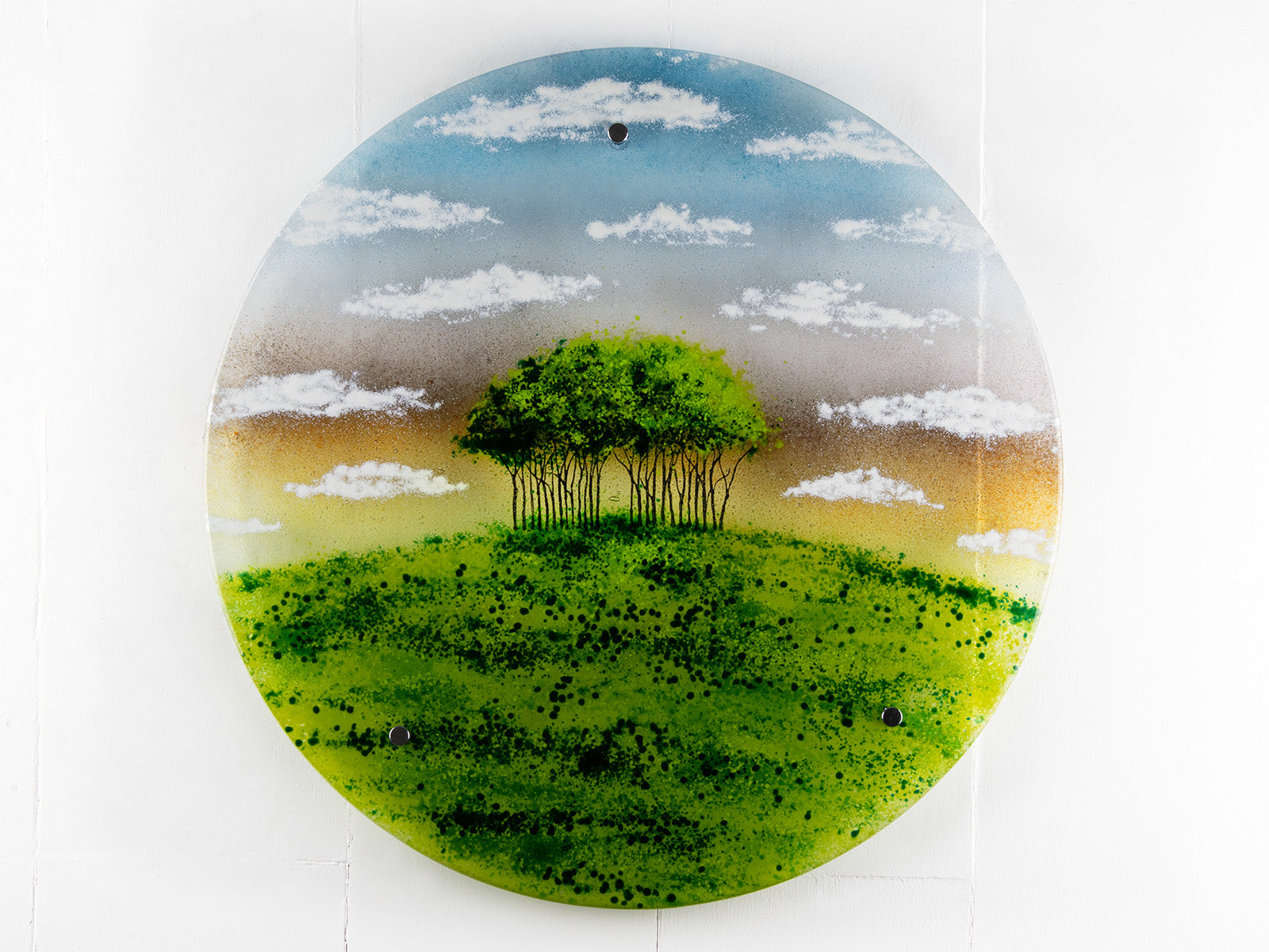 A fused glass round panel featuring a design of the "Nearly Home Trees" located on a hill over-looking the A30. 
