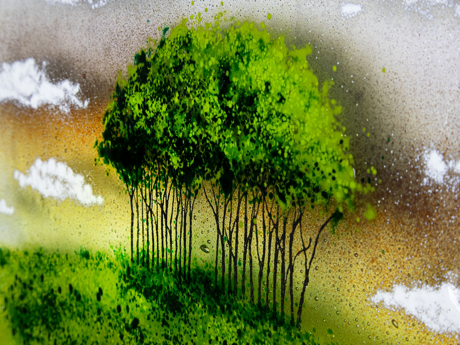 Details of the trees on a a fused glass round panel featuring a design of the "Nearly Home Trees" located on a hill over-looking the A30. 