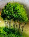 Details of the trees on a a fused glass round panel featuring a design of the "Nearly Home Trees" located on a hill over-looking the A30. 