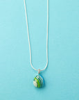 Fused glass small pendant necklace, handmade in ocean blue and green hues, hung on a sterling silver chain. 