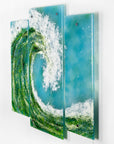 A fused glass triptych featuring a giant ocean wave, with aqua and sea green colours and white texture. 